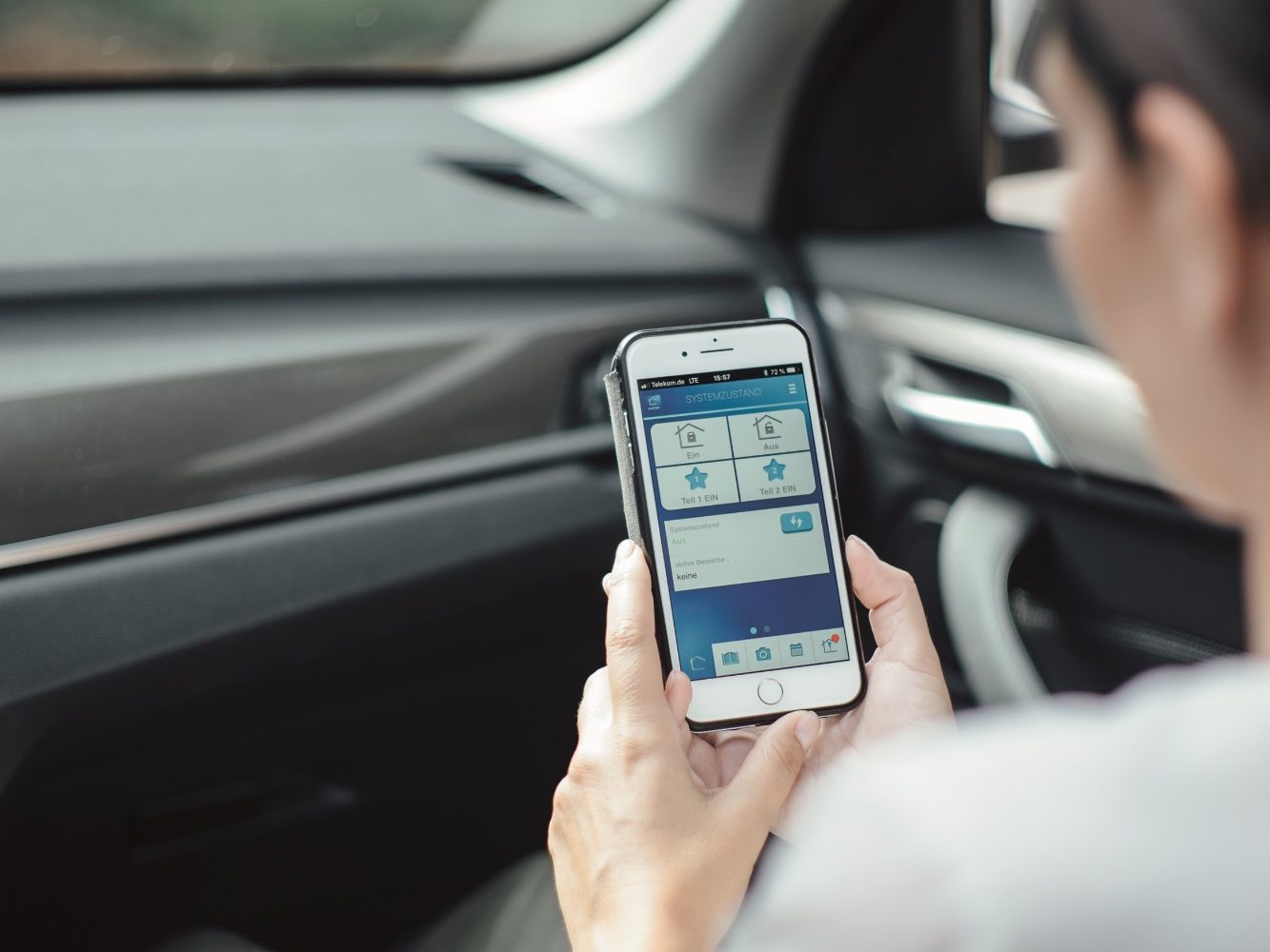 Remote Kontrolle Einbruchschutz Mann überprüft mit dem Handy über eine App, ob im seinem Haus alles in Ordnung ist und kein Einbruch stattgefunden hat.